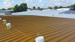 New paint coat being applied to steel commercial roof in San Antonio | WeatherTech Roofing San Antonio Roofer Contractor Company Residential and Commercial