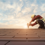 Roofer in safety helmet and harness drilling on a roof in San Antonio.